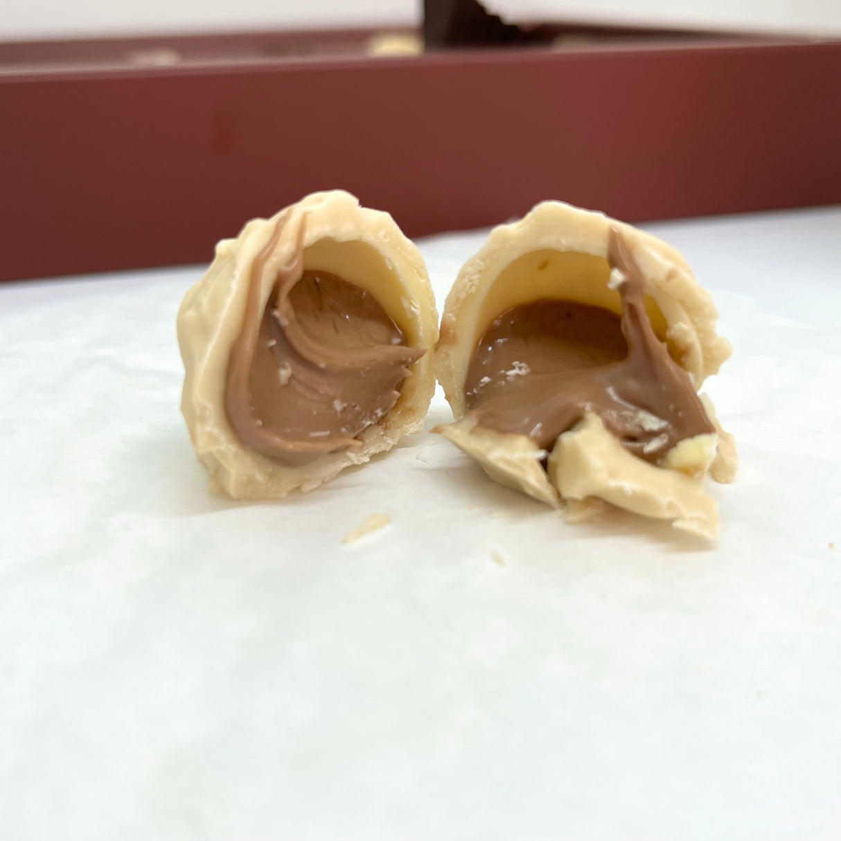 شوكولاتة إيما بالحليب وكرات الشوكولاتة البيضاء المحشوة بكريمة البندق - علبة عيد ميلاد مجيد - 250غ